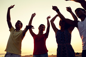 Image showing smiling friends dancing on summer beach