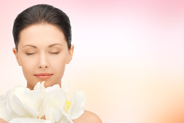 Image showing beautiful woman smelling flowers with closed eyes