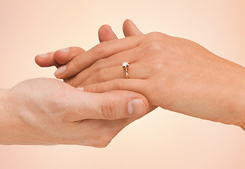 Image showing close up of man and woman hands with wedding ring