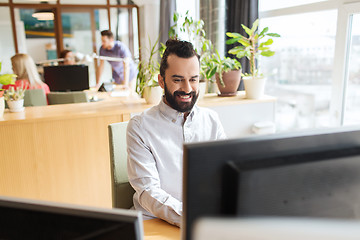 Image showing happy creative male office worker with computer
