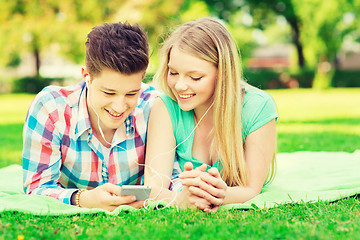 Image showing smiling couple with smartphone and earphones