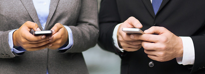 Image showing businessman and businesswoman with smartphones