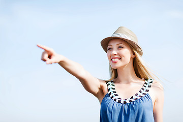 Image showing girl in hat showing direction on the beach