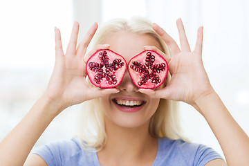 Image showing happy woman covering eyes with pomegranate