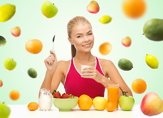 Image showing woman eating yogurt and having healthy breakfast