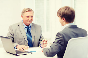 Image showing older man and young man having meeting in office