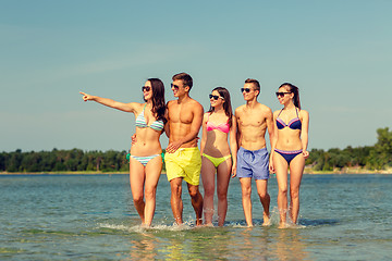 Image showing smiling friends in sunglasses on summer beach