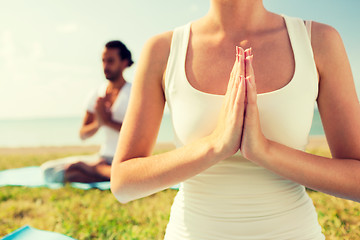 Image showing close up of couple making yoga exercises outdoors