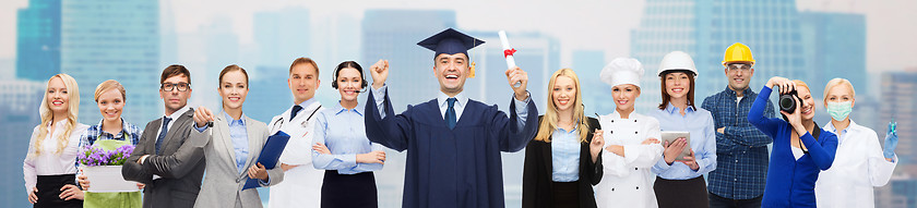 Image showing happy bachelor with diploma over professionals