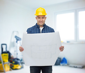 Image showing smiling male builder in helmet with blueprint