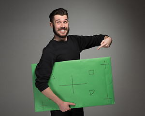 Image showing The smiling man as businessman with green panel