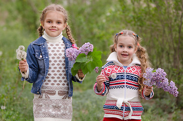 Image showing Two girls with dandelions and lilacs