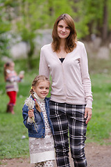 Image showing Young woman a daughter with dandelions in hands