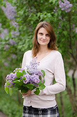 Image showing Portrait young European girl with a lilac in the hands of