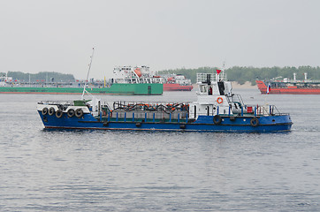 Image showing small boat on background of standing in the roads tankers