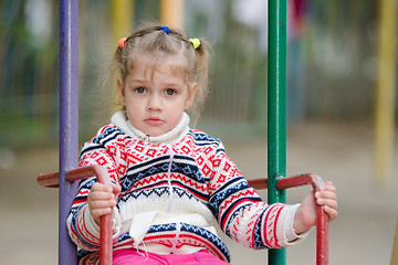 Image showing Upset four-year girl riding on a swing