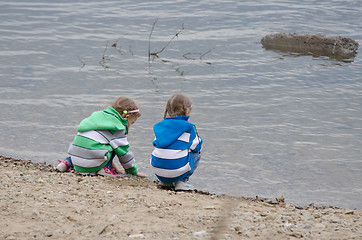 Image showing Two girls sitting on a river bank