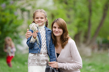 Image showing young woman embraces her daughter with dandelions