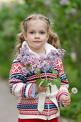 Image showing Portrait of girl with lilacs and dandelions in the hands