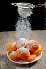 Image showing pours sugar over donuts