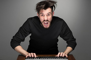 Image showing Crazy businessman sitting at table