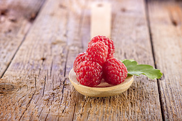 Image showing fresh berries in wooden spoon on wooden table