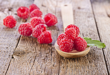 Image showing fresh raspberry in wooden spoon on wooden table