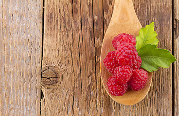 Image showing fresh raspberry in wooden spoon on wooden table