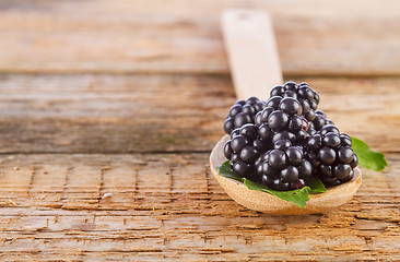 Image showing blackberries with spoon on wooden background