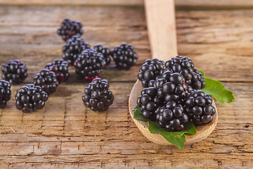 Image showing blackberries with spoon on wooden background