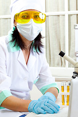 Image showing scientist with microscope and computer