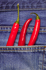 Image showing hot chili peppers in a jeans pocket