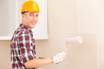 Image showing smiling young painter with a roller