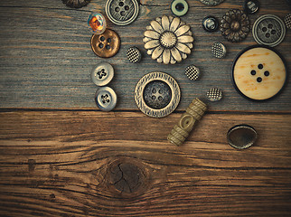 Image showing Vintage buttons on the old wooden surface