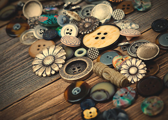 Image showing Vintage buttons in large numbers scattered on aged wooden boards