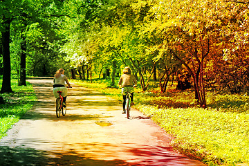 Image showing Two girls ride bikes  