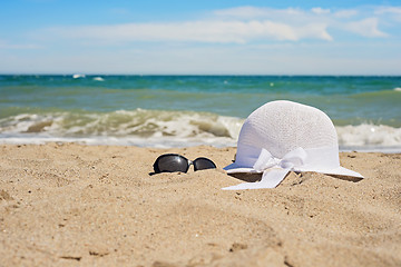 Image showing Wicker white hat and sun glasses on the beach