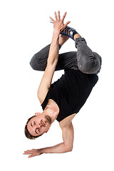 Image showing Break dancer doing one handed handstand against a white background
