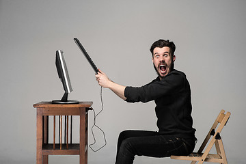 Image showing Angry man is destroying a keyboard