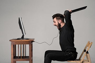 Image showing Angry man is destroying a keyboard