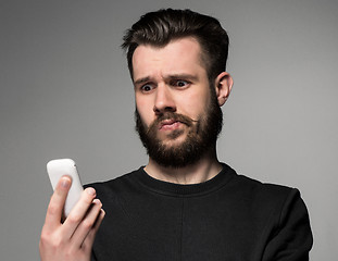 Image showing Portrait of puzzled man talking on the phone