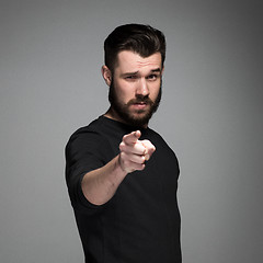 Image showing Young man with beard and mustaches, finger pointing towards the camera