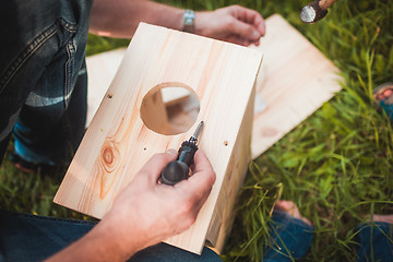 Image showing Male hands with wooden birdhouse