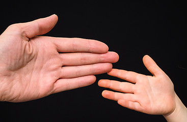 Image showing Closeup of small and big caucasian hand palms touching isolated 