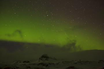 Image showing Northern lights with snowy mountains in the foreground