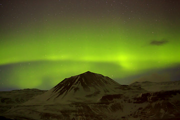 Image showing Northern lights with snowy mountains in the foreground