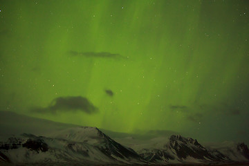 Image showing Northern lights with snowy mountains in the foreground