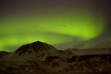 Image showing Northern lights with snowy mountains in the foreground