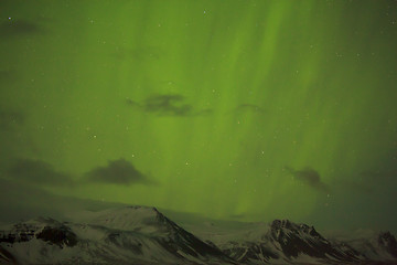 Image showing Northern lights with snowy mountains in the foreground