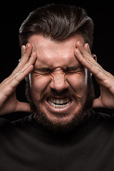 Image showing Stressed businessman with a headache over black
